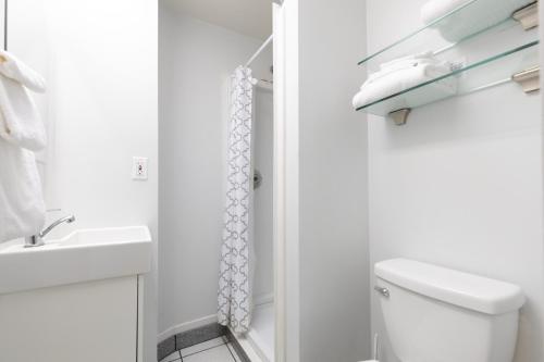 a white bathroom with a toilet and a sink at Ocean View Hideaway Unit #3 in San Clemente