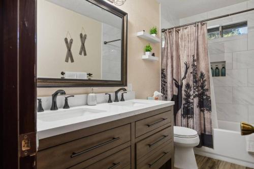 uma casa de banho com um lavatório, um WC e um espelho. em Chateau Oso Grande in Big Bear em Big Bear City
