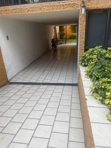 an empty walkway leading to a building with a door at Habitación con baño privado exterior in Mexico City