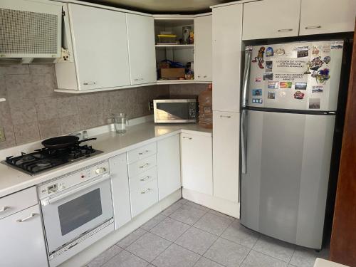 a kitchen with white cabinets and a refrigerator at Habitación con baño privado exterior in Mexico City