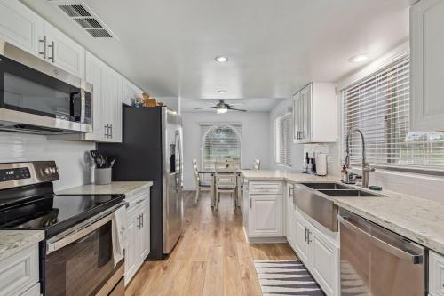 a kitchen with white cabinets and stainless steel appliances at New remodeled home on golf course in Mesa