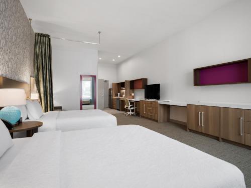 a hotel room with two beds and a flat screen tv at Home2 Suites By Hilton Round Rock Medical Center in Round Rock