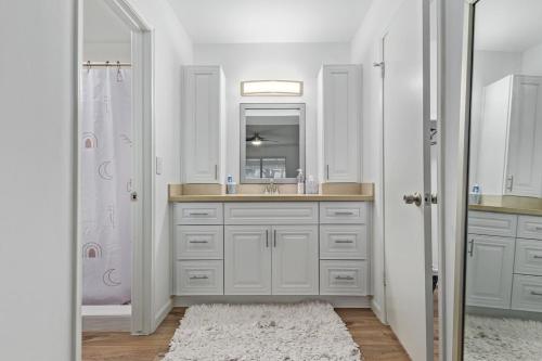 a white bathroom with a sink and a mirror at New remodeled home on golf course in Mesa