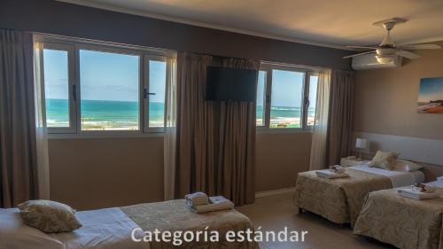 a hotel room with two beds and a view of the ocean at Hotel AATRAC in Mar del Plata
