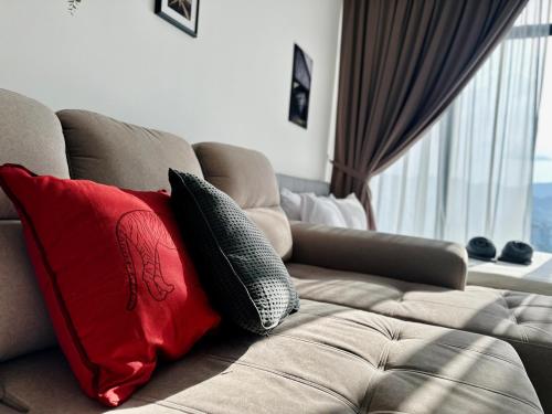 a couch with two pillows on it with a window at New 2BR Georgetown Warm and Lovely Homestay 10pax-无敌美景两房民宿 Beacon Executive Suite in George Town