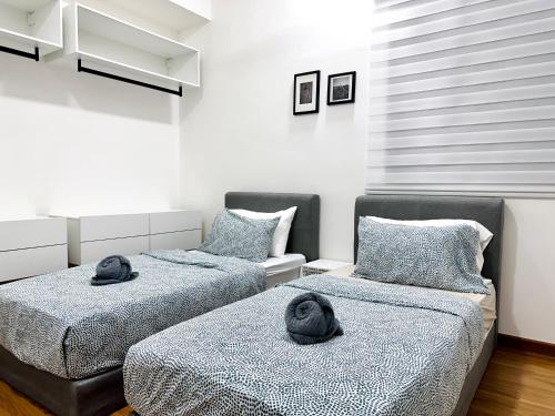 two beds with hats on them in a room at New 2BR Georgetown Warm and Lovely Homestay 10pax-无敌美景两房民宿 Beacon Executive Suite in George Town