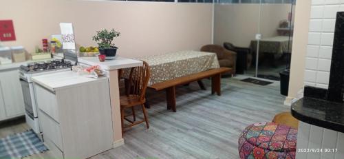 una cucina con piano cottura e tavolo con di Apartamento meia praia a Itapema