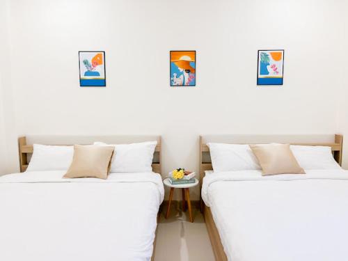 duas camas sentadas uma ao lado da outra num quarto em The Teak Poolvilla em Sattahip