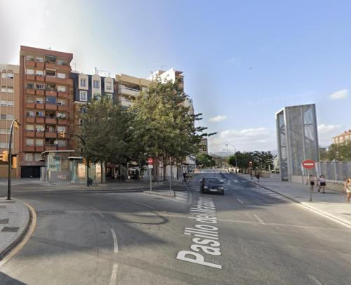 an empty city street with a car driving down the street at Bubu - Nuevo edificio de apartamentos en el centro in Málaga