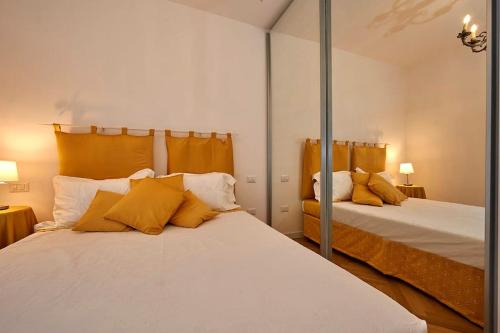 1 dormitorio con 2 camas con almohadas amarillas en Liberty Dream, fascino a Vicenza, en Vicenza