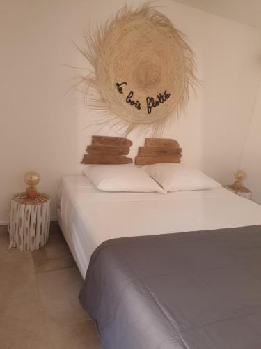 a bedroom with a bed with a sign on it at Appartement LE BOIS FLOTTE in Saintes-Maries-de-la-Mer