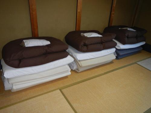 a room with three stacks of pillows on top at Guest Inn Chita in Kyoto