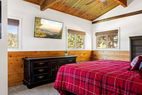 1 dormitorio con cama roja y techo de madera en Hygee Frosk, en Big Bear Lake