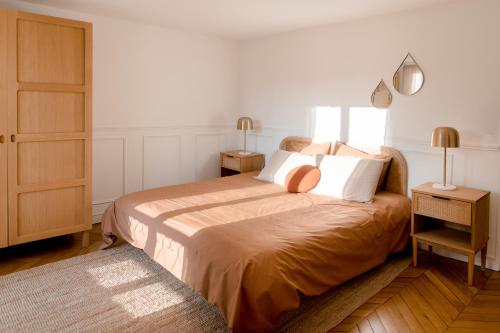 a bedroom with a bed with two lamps and a door at Logement entier ou à partager dans maison familiale à Rueil Malmaison, proche de Paris La Défense in Rueil-Malmaison