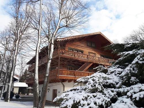 Cabaña de madera grande con terraza en la nieve en Dworzysko, en Szczawno-Zdrój