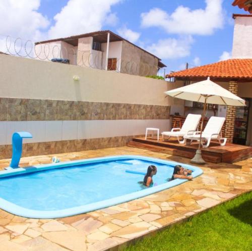 a pool with two people swimming in it at POUSADA CAMINHO do MAR in Pôrto de Pedras