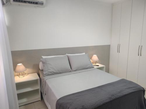 a bedroom with a white bed and two night stands at Studio In - Apt° 205 com Garagem in Brasilia