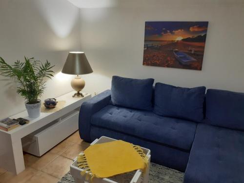 a living room with a blue couch and a table at Guest House Vila Bak in Budva