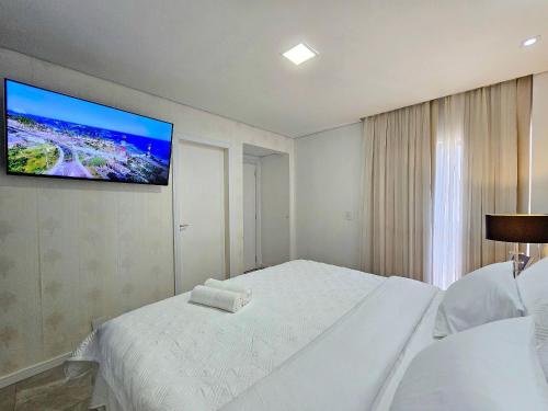 a bedroom with a bed with a tv on the wall at Sofisticado APT ao lado do Paraguai 3 quartos in Foz do Iguaçu
