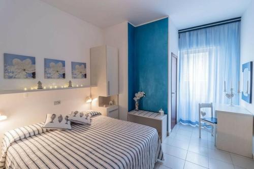 ジュリアノーヴァにあるHotel Coralloの青い壁のベッドルーム1室(ベッド1台付)