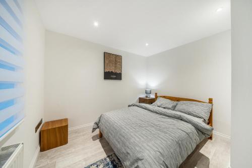 a bedroom with a bed in a white room at Two Bed Home In the Heart of Egham in Egham