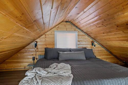 Cama en habitación con techo de madera en Calipe Cottage, en Sugarloaf