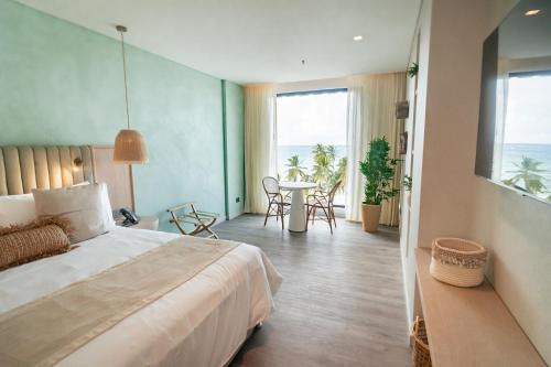 a bedroom with a bed and a table with chairs at Nattivo Collection Hotel in San Andrés