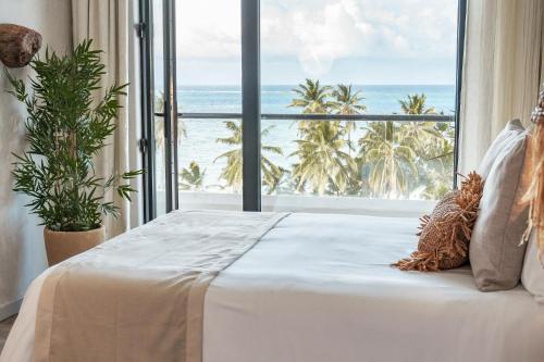 a bedroom with a bed with a view of the ocean at Nattivo Collection Hotel in San Andrés
