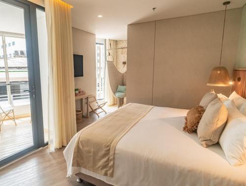a bedroom with a large bed with a large window at Nattivo Collection Hotel in San Andrés