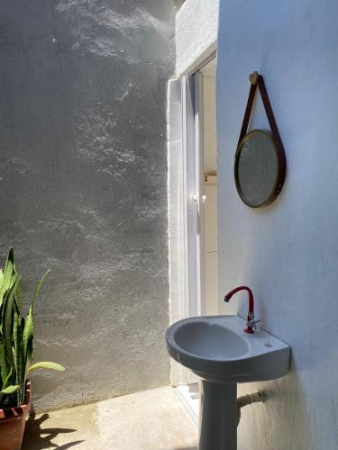 a bathroom with a blue sink and a mirror at Hostel Aconchego do Arraial in Arraial d'Ajuda