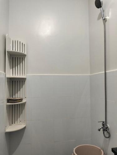 a white bathroom with a shower and a toilet at Plumera Homes in Lapu Lapu City