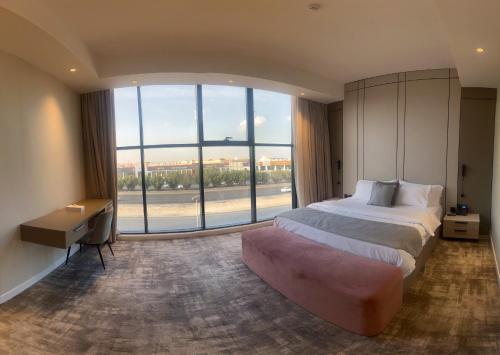 جراند ريجس Grand Regis في الرياض: غرفة نوم بسرير كبير ونافذة كبيرة