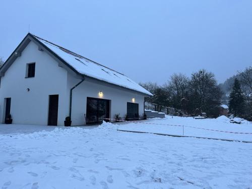a white barn with snow on the ground at Apartmány Jakubov in Vojkovice