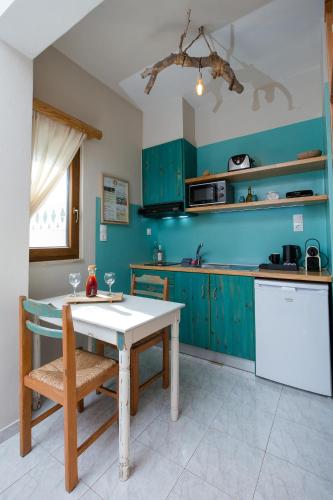 a kitchen with green cabinets and a table and chairs at Arodamos Studios & Apts in Kissamos