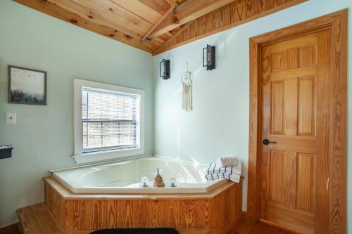 Cette chambre dispose d'une baignoire et d'une porte en bois. dans l'établissement Azure Woods Grill Fireplace GameArea CommunityPool, à Townsend
