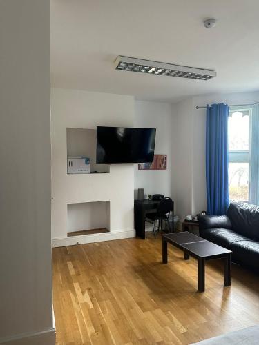 a living room with a couch and a table at 3 Luxury En-suite Bedrooms in Cardiff