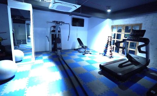 a room with a gym with a treadmill and a mirror at Grand River View Hotel - Rajshahi in Rājshāhi