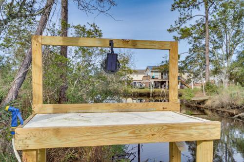 a wooden chair sitting next to a body of water at Bay St Louis Home with Private Dock and Kayaks! in Shoreline Park