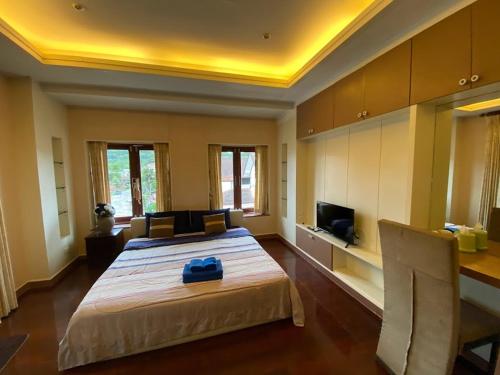 a bedroom with a large bed with a blue bag on it at Phuket Private Pool and Thai Villa Style by Andaman Home in Phuket Town