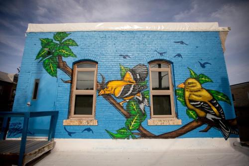 um edifício azul com uma pintura de pássaros em Goldfinch Suites em Elkader