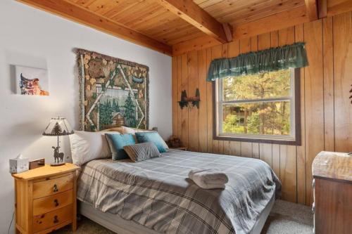 a bedroom with a bed and a window at Knoll Lake Cabin in Big Bear Lake in Big Bear Lake