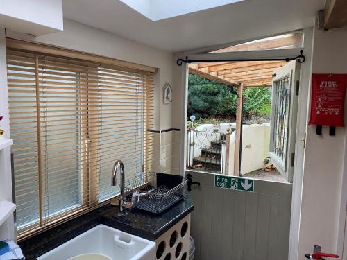 eine Küche mit einem Waschbecken und einem Fenster in der Unterkunft Lavender Cottage, Grade 2 Listed Period Stone Built Cottage In Pickering, North Yorkshire in Pickering