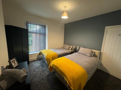 a bedroom with two beds and a window at Stunning 4 bedroom 8 person 2 bathroom house! in Hull