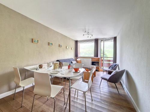 une salle à manger avec une table et des chaises blanches dans l'établissement Appartement spacieux et renové Centre station Balcon - FR-1-344-1022, aux Menuires