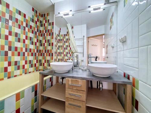 une salle de bain avec deux lavabos et un miroir dans l'établissement Appartement spacieux et renové Centre station Balcon - FR-1-344-1022, aux Menuires