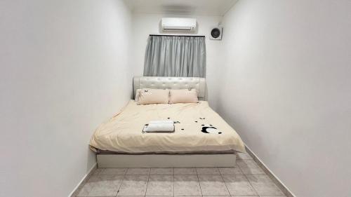 a small bedroom with a bed in a white room at PandaHomestay28 in Skudai