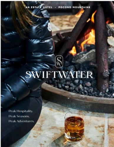 une couverture magazine avec un verre de whisky près d'un feu dans l'établissement The Swiftwater, à Swiftwater