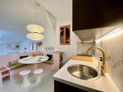 uma cozinha com um lavatório e uma mesa com bancos em Charmant cocon sous les toits de Bordeaux em Bordeaux