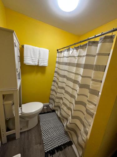 a bathroom with a toilet and a shower curtain at Cottage in Stock Island in Key West
