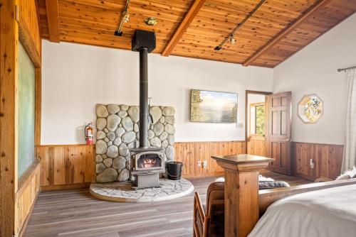 um quarto com um fogão a lenha num quarto com uma cama em Ski Slope Haven em Big Bear Lake